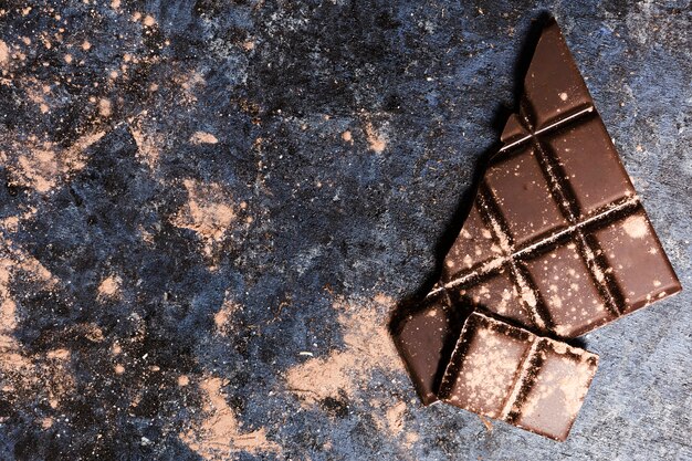 Gratis foto plat leggen chocolade bedekt met cacao op grunge tafel