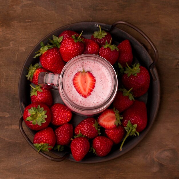 Plat leggen van aardbeienmilkshake met fruit