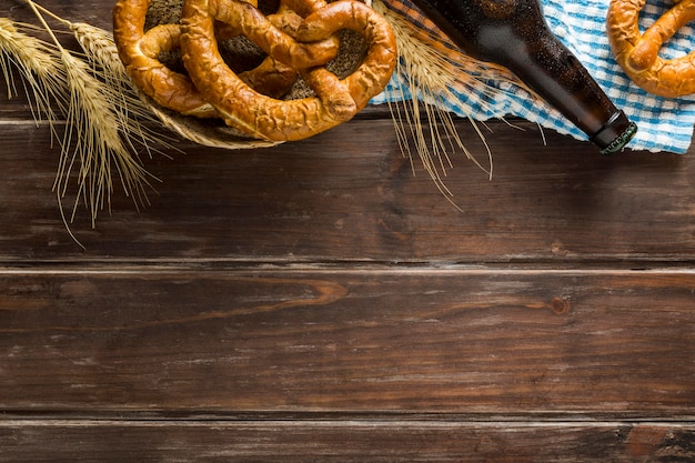 Plat leggen van bierfles met kopie ruimte en pretzels