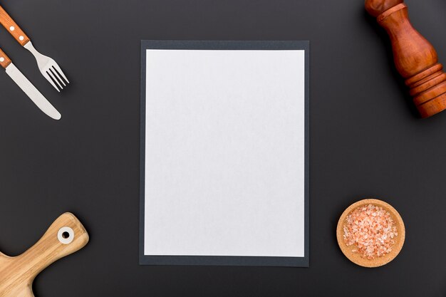 Plat leggen van blanco menu papier met mes en vork