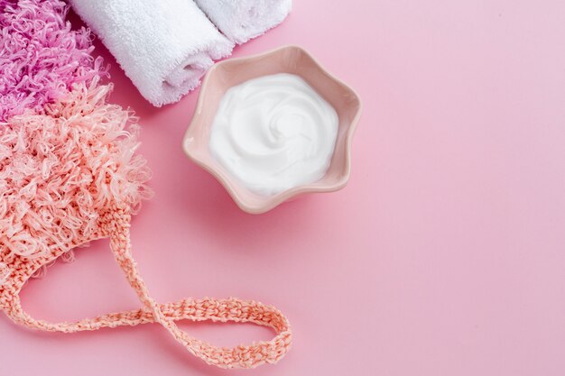 Plat leggen van body butter cream op roze achtergrond