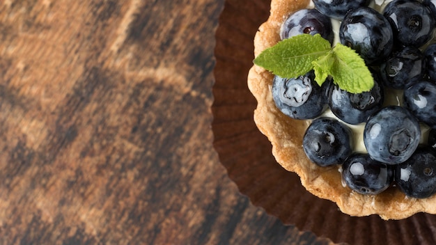 Gratis foto plat leggen van bosbessendessert met munt en exemplaarruimte