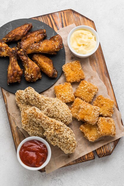 Plat leggen van gebakken kip en nuggets met twee verschillende sauzen