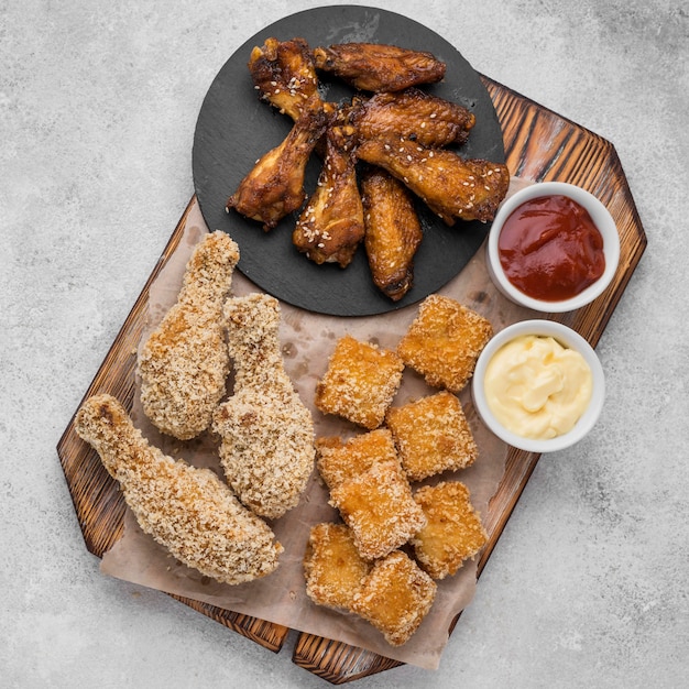 Plat leggen van gebakken kip en nuggets met verschillende sauzen