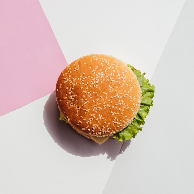 Plat leggen van hamburger op eenvoudige achtergrond