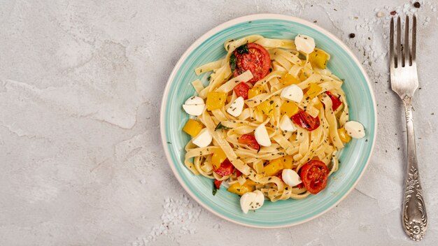 Plat leggen van heerlijke Italiaanse pasta op effen achtergrond