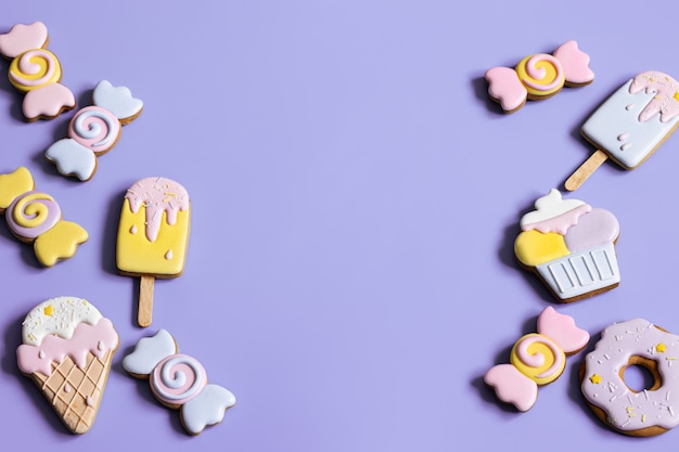 Plat leggen van heldere geglazuurde peperkoekkoekjes op een blauwe achtergrondkopieerruimte.