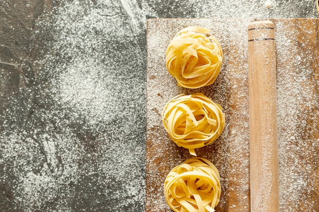 Gratis foto plat leggen van pasta en deegroller met kopie ruimte