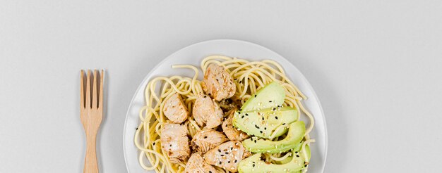 Plat leggen van pasta met vlees en avocado op plaat