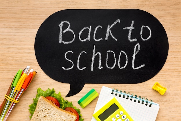 Gratis foto plat leggen van schoolbenodigdheden met sandwich en notebook