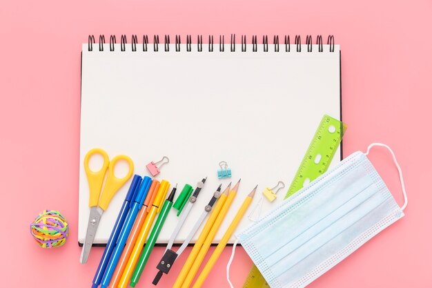 Plat leggen van terug naar schoolbenodigdheden met notebook en potloden
