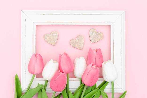 Gratis foto plat leggen van tulpen met frame en harten