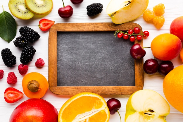 Plat leggen van verse bessen en fruit met schoolbord