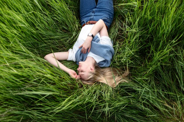 Plat leggen van vrouw poseren in gras