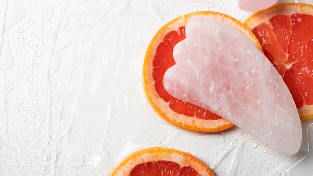 Platliggend gua sha en grapefruit arrangement