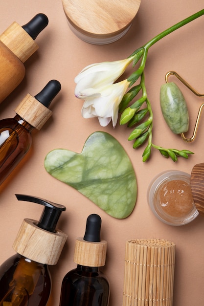 Platliggend gua sha en verzorgingsproducten arrangement