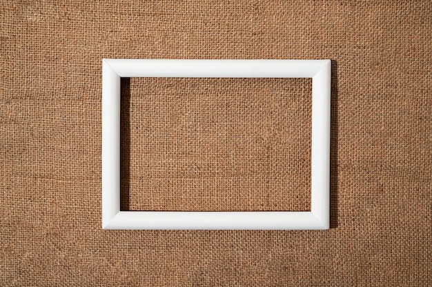 Gratis foto platliggend wit frame op gestructureerd materiaal