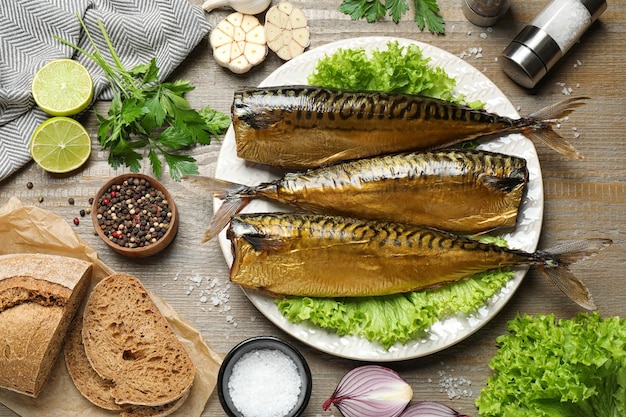 Gratis foto platliggende compositie met smakelijke gerookte vis op houten tafel