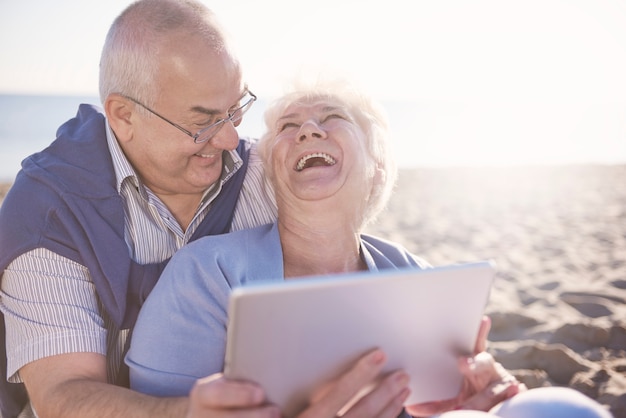 Plezier hebben met een digitale tablet op het strand