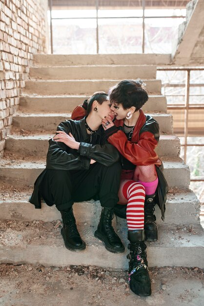 Pop punk esthetisch portret van vrouwen die poseren en kussen in een gebouw op trappen