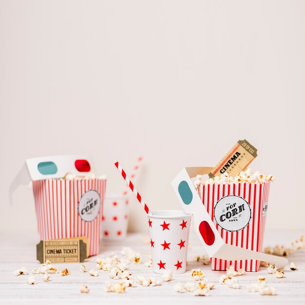 popcorn; bioscoopkaartje; beschikbaar glas met het drinken van stro en popcorndoos op lijst tegen witte achtergrond