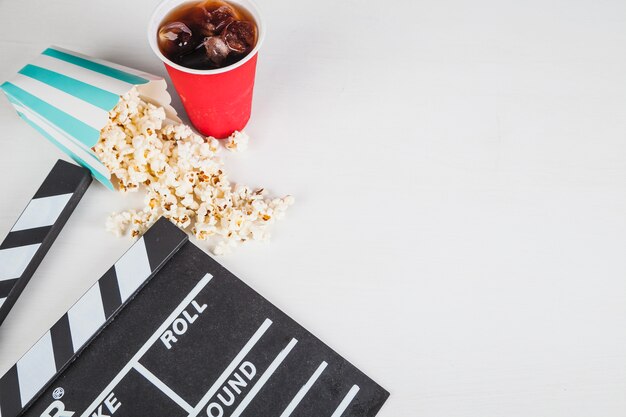 Popcorn en cola dichtbij clapperboard