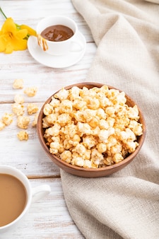 Popcorn met karamel in houten kom en een kopje koffie