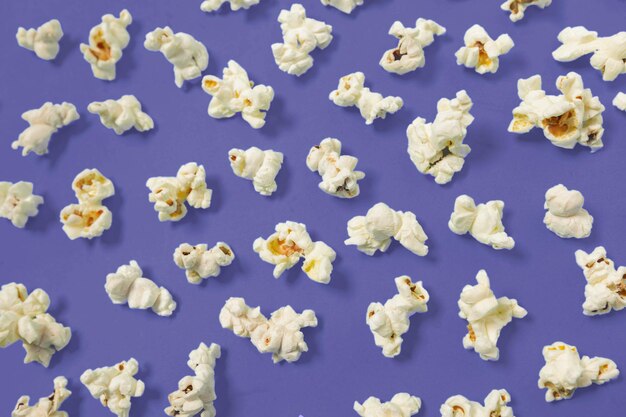 Popcorn op donkerpaarse kleur achtergrond bovenaanzicht