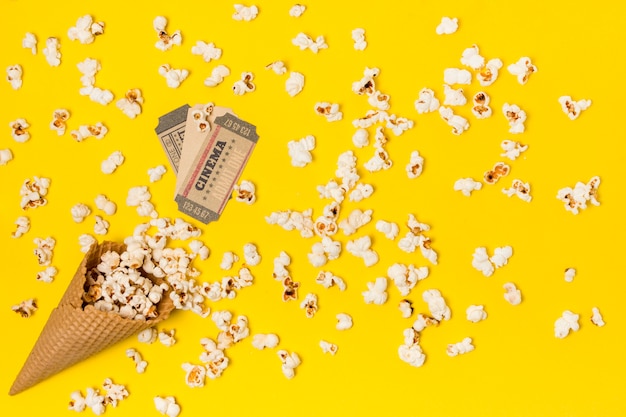 Gratis foto popcorns gemorst uit de wafelkegel met bioscoopkaartje