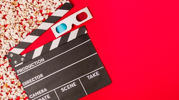 Popcorns met clapperboard en 3d glazen op rode achtergrond