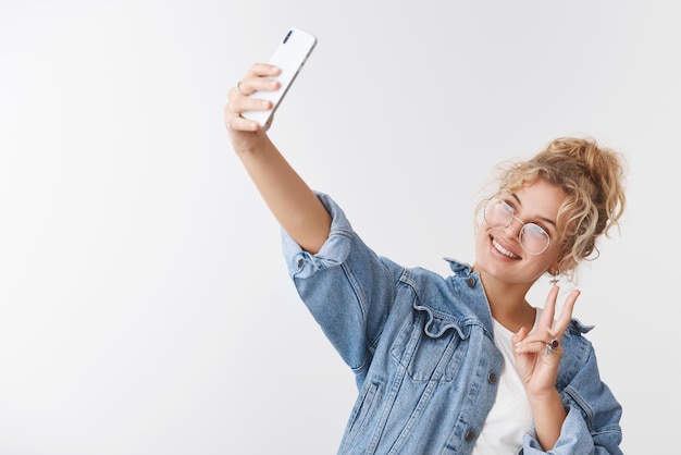 populaire vrouwelijke blonde internetblogger die selfie maakt