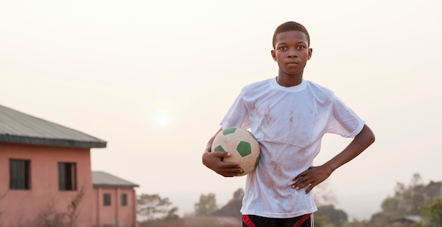 Gratis foto portret afrikaans kind met voetbalbal