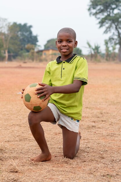 Gratis foto portret afrikaans kind met voetbalbal