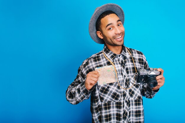 Portret blije knappe jongen positieve emoties uitdrukken. Reizen, toerist, weekend, vakantie, toerisme, camera, kaart, vrolijke stemming, glimlachen, geluk.