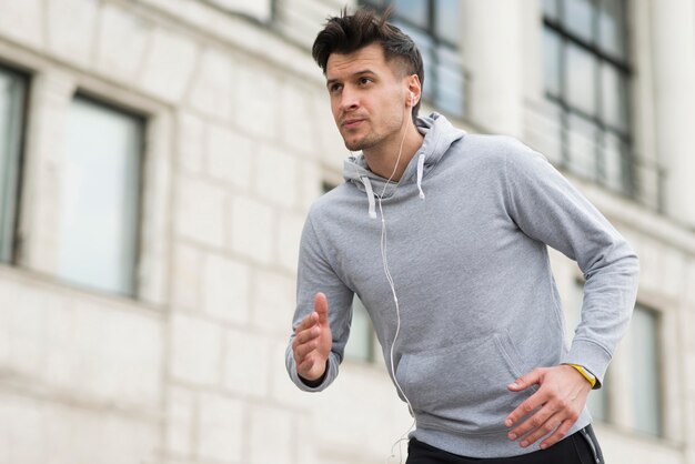 Portret dat van geschikte atleet in openlucht loopt