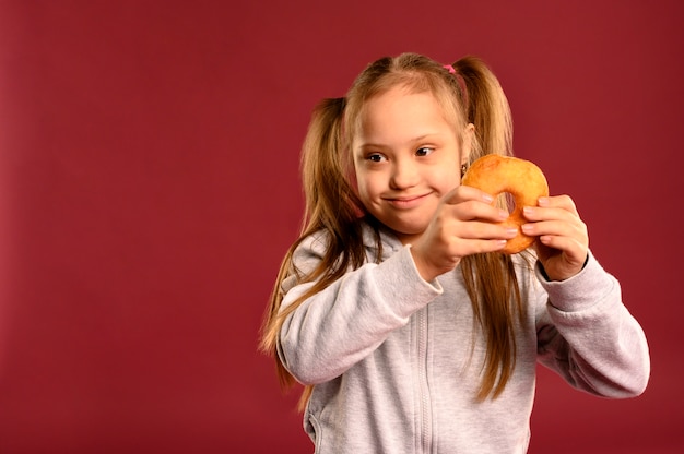 Portret dat van jong meisje smakelijke doughnut houdt