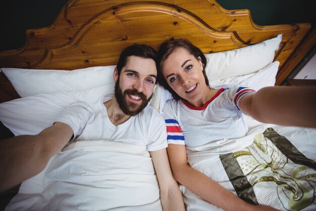 Portret dat van paar samen op bed ligt