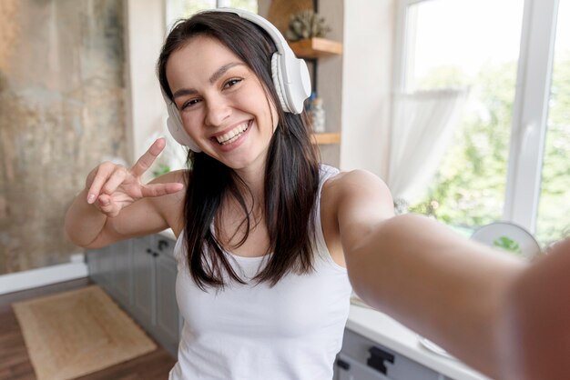 Portret dat van positieve vrouw een selfie neemt