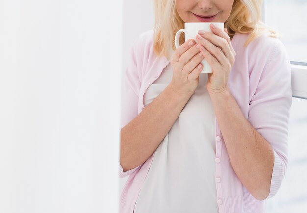 Gratis foto portret dat van rijpe vrouw een kop van koffie houdt