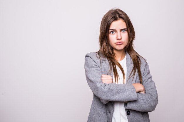 Portret die van boze vrouw zich met gevouwen wapens bevinden geïsoleerd op grijze achtergrond