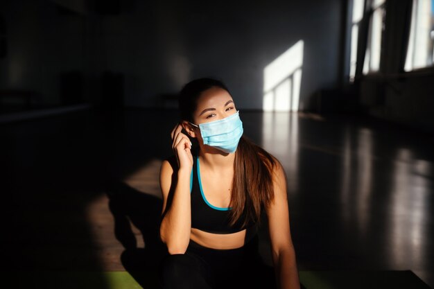 Portret die van geschikte vrouw een beschermend gezichtsmasker zetten. Sportieve vrouw die gezichtsmasker draagt.