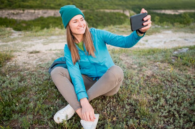Portret die van jonge vrouw een selfie in openlucht nemen