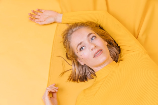 Portret die van vrouw in een gele scène liggen