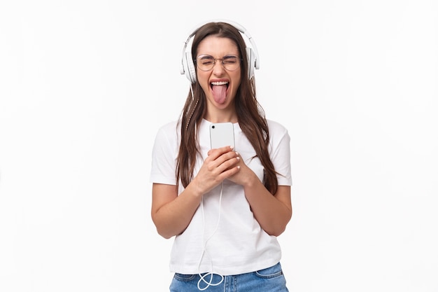 portret expressieve jonge vrouw met mobiele muziek luisteren