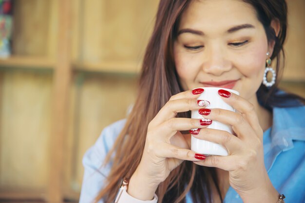 Portret gelukkige jonge aziatische dame in koffiewinkel