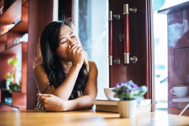 Portret het Aziatische vrouw glimlachen ontspant in de koffie van de koffiewinkel