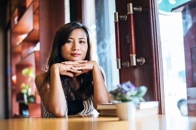 Portret het Aziatische vrouw glimlachen ontspant in de koffie van de koffiewinkel