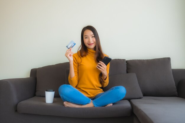 Portret jonge Aziatische vrouw met behulp van laptopcomputer met slimme mobiele telefoon en creditcard voor online winkelen