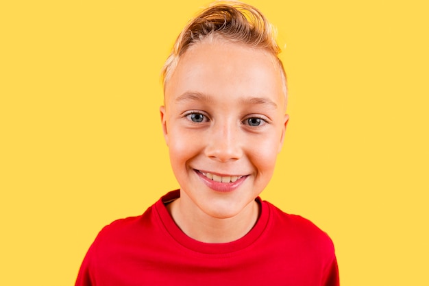 Portret jonge jongen die op gele achtergrond glimlachen