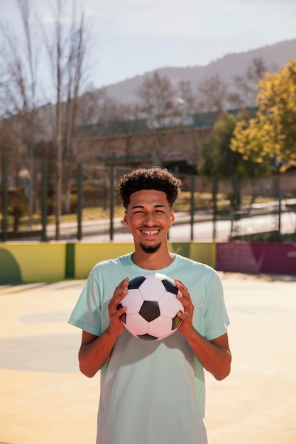 Portret jonge man met voetbal bal